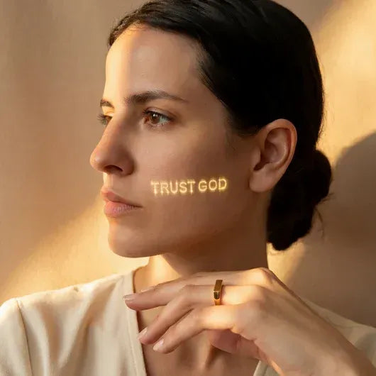 The Secret Light Projection Ring gold, worn with the hidden message projected in light